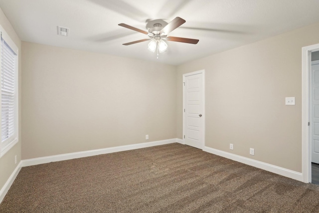 unfurnished bedroom with visible vents, dark carpet, baseboards, and ceiling fan