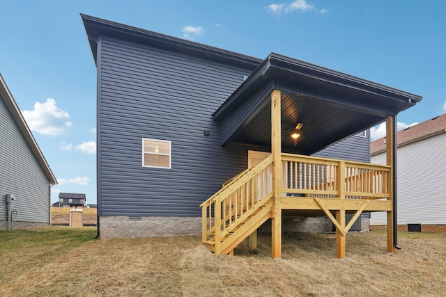 rear view of house featuring crawl space, a lawn, and a deck