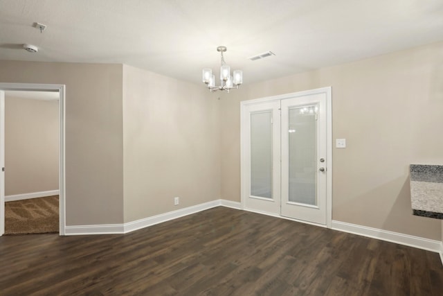 spare room featuring dark wood-style flooring, visible vents, and baseboards