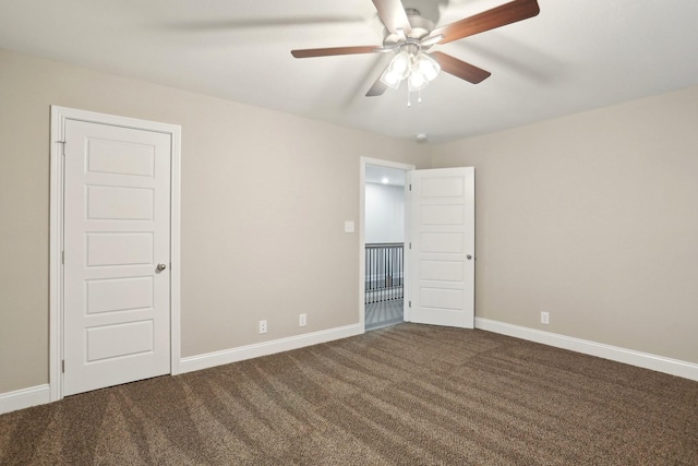 unfurnished room featuring dark carpet, baseboards, and ceiling fan