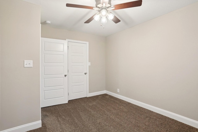 unfurnished bedroom featuring a ceiling fan, dark colored carpet, and baseboards