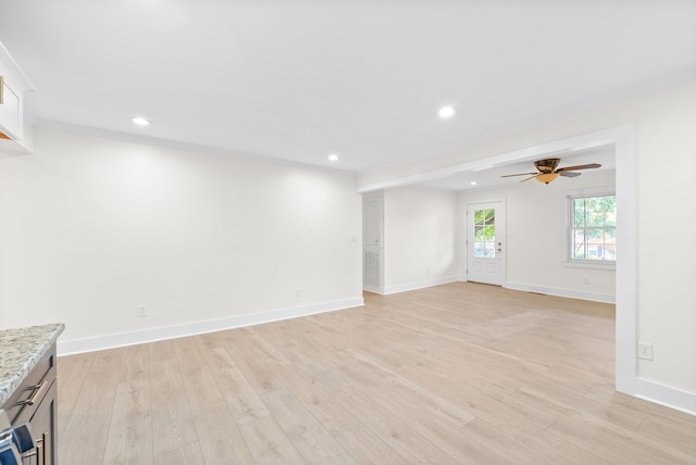 unfurnished living room with ceiling fan, crown molding, and light hardwood / wood-style flooring