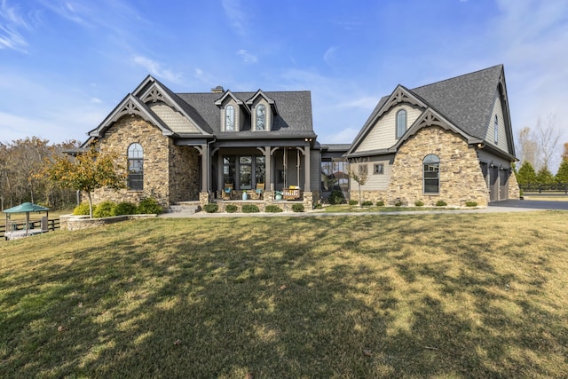 craftsman-style home featuring a front yard, a porch, and a garage