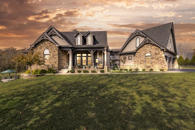 view of front of house with a lawn, a garage, and a porch