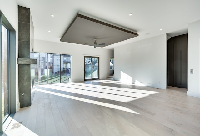 unfurnished living room featuring light wood-type flooring and ceiling fan