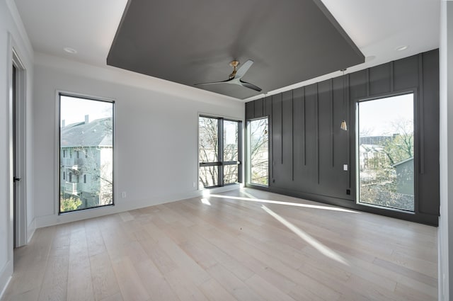 empty room featuring ceiling fan, light hardwood / wood-style flooring, and plenty of natural light