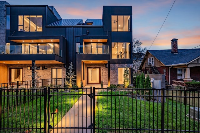 view of front of property featuring a yard and a balcony