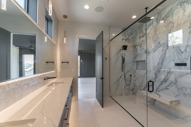 bathroom with a shower with door, tile patterned floors, decorative backsplash, tile walls, and vanity