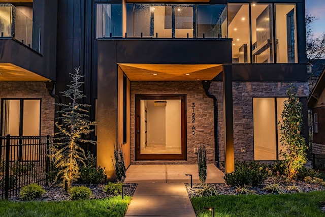 exterior entry at dusk featuring a balcony