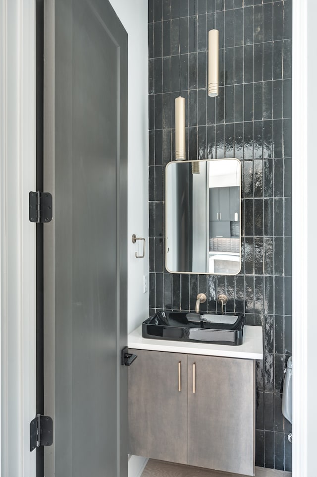 bathroom featuring vanity and backsplash