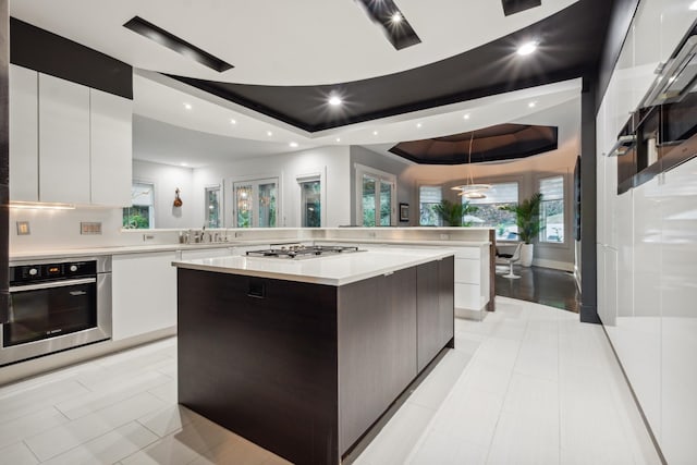 31 Annandale, Nashville, TN 37215 - kitchen featuring stainless steel oven, modern cabinets, a large island, light countertops, and a raised ceiling