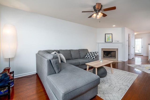 living room featuring ceiling fan and dark hardwood / wood-style flooring