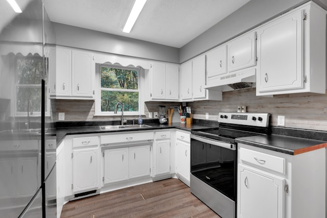 kitchen with stainless steel appliances, range hood, sink, white cabinets, and dark hardwood / wood-style flooring