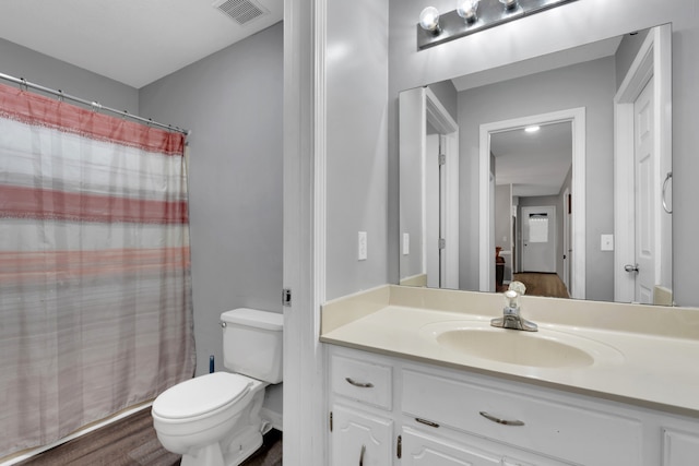 bathroom featuring vanity, toilet, a shower with shower curtain, and hardwood / wood-style floors