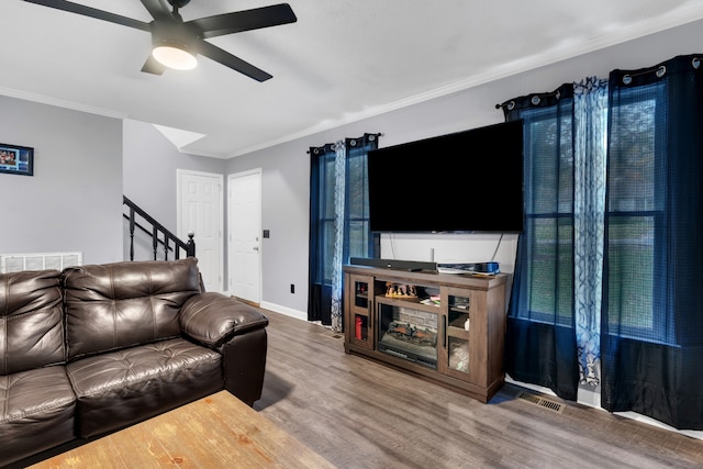 living room with ornamental molding, hardwood / wood-style flooring, and ceiling fan