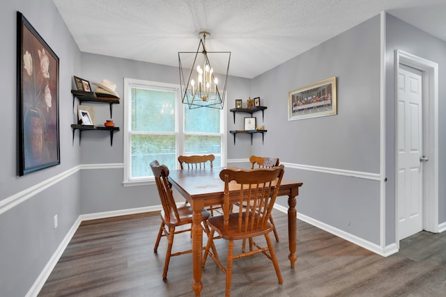 dining area with a textured ceiling, a chandelier, and dark wood-type flooring