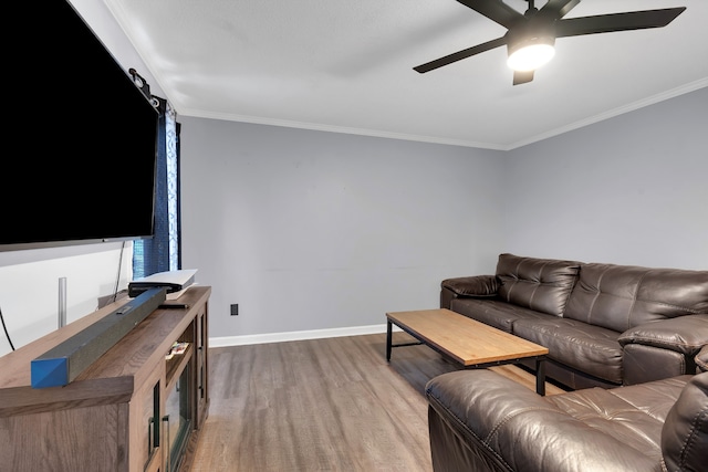 living room with crown molding, a barn door, wood-type flooring, and ceiling fan