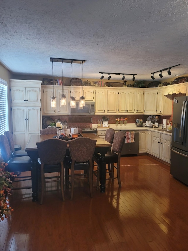 47 Hickory Ln, Sugar Tree, TN 38380 - kitchen with black fridge, stainless steel microwave, dark wood-style floors, dishwashing machine, and a textured ceiling