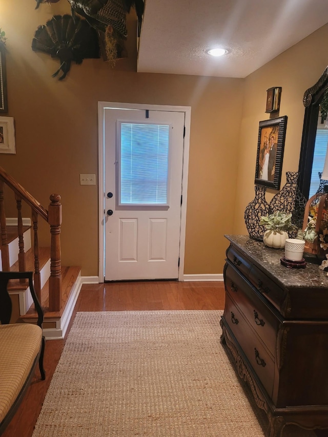 47 Hickory Ln, Sugar Tree, TN 38380 - doorway to outside featuring baseboards, wood finished floors, and stairway