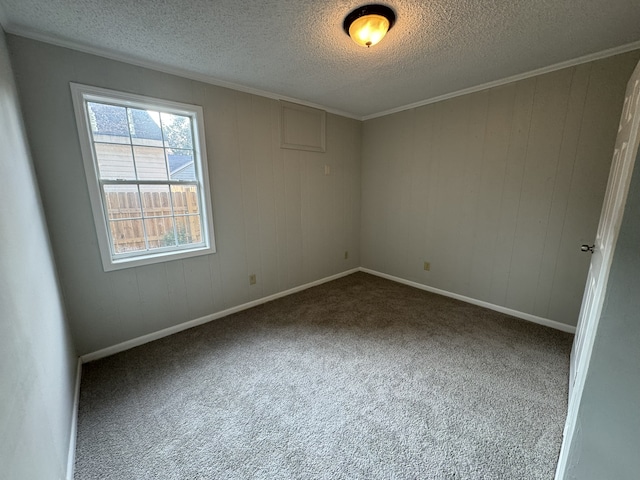 spare room with carpet floors, a textured ceiling, and crown molding