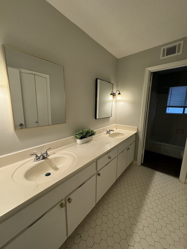 bathroom featuring vanity, a textured ceiling, and tile patterned floors