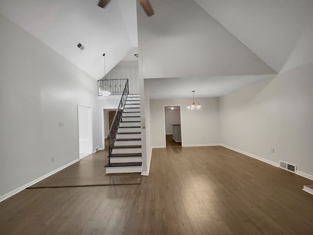 unfurnished living room featuring high vaulted ceiling, dark hardwood / wood-style floors, and an inviting chandelier