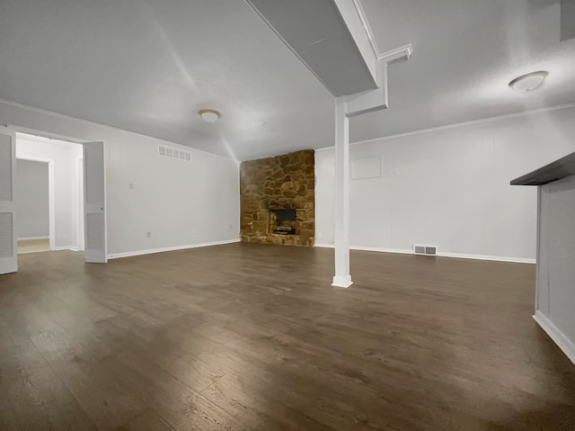 unfurnished living room featuring dark hardwood / wood-style flooring and a stone fireplace