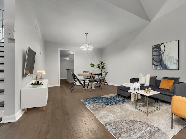 living room with an inviting chandelier, vaulted ceiling, and dark hardwood / wood-style floors