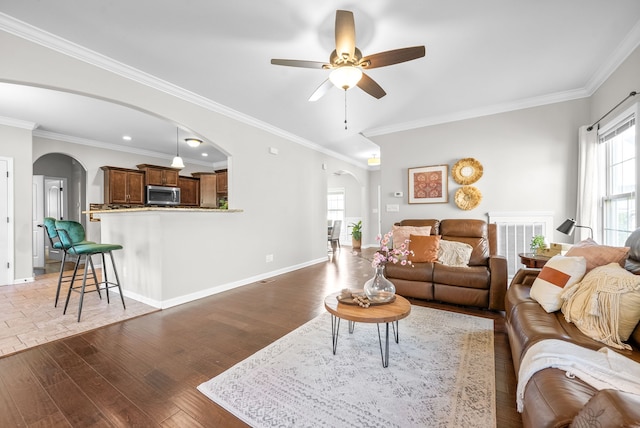 living room with crown molding, light hardwood / wood-style floors, and ceiling fan