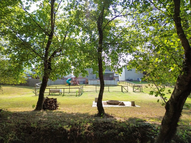 surrounding community with an outdoor fire pit and a lawn