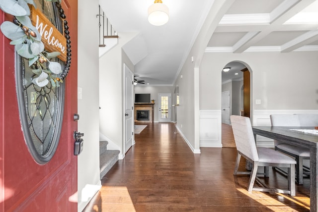 foyer featuring beam ceiling, ceiling fan, dark wood-type flooring, crown molding, and coffered ceiling