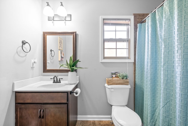 bathroom with toilet, walk in shower, and vanity