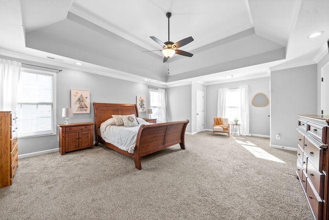 bedroom featuring ceiling fan, a raised ceiling, ornamental molding, and light carpet