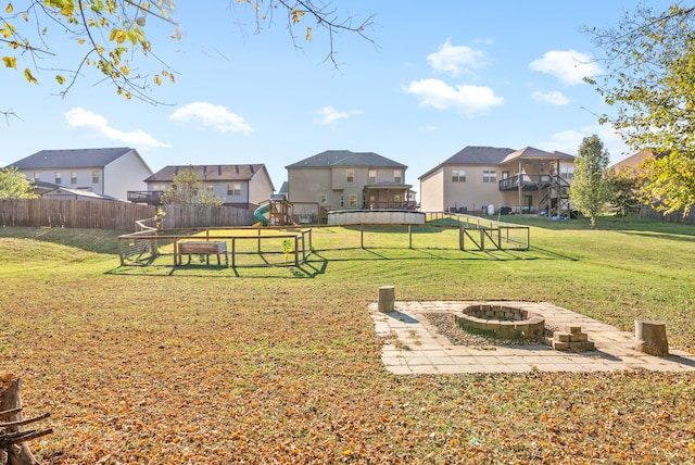 view of yard with an outdoor fire pit and a playground