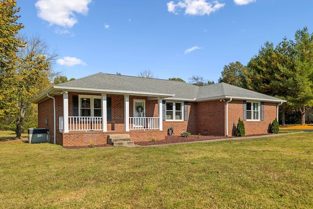 ranch-style home featuring cooling unit, a front lawn, and covered porch