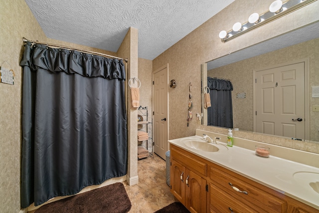 bathroom featuring vanity, a textured ceiling, and walk in shower