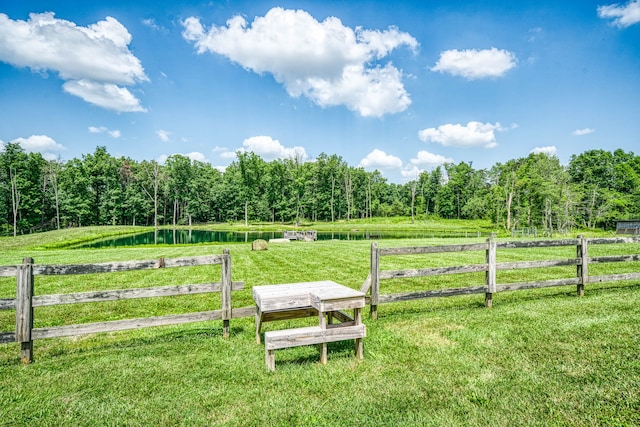 exterior space with a rural view, a water view, and a lawn