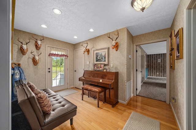 sitting room with a textured ceiling and light wood-type flooring