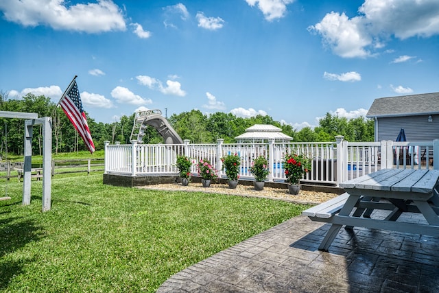 view of yard with a wooden deck and a patio