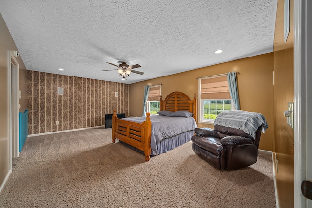 bedroom featuring a textured ceiling, carpet floors, and ceiling fan