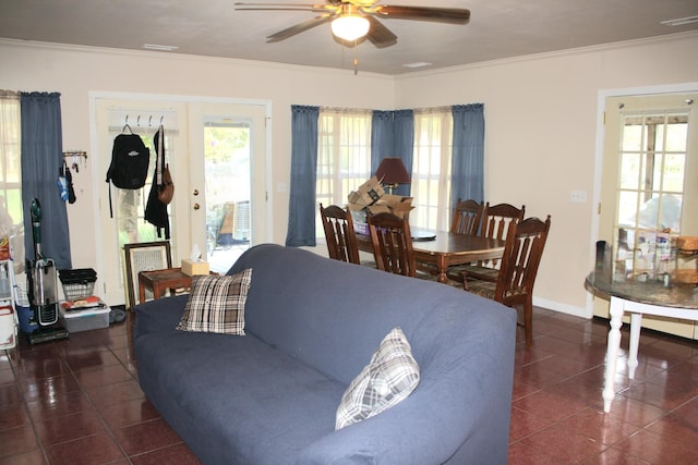 living room with dark tile patterned floors, ornamental molding, a ceiling fan, and visible vents