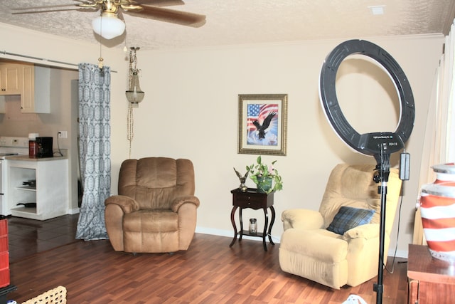 living area featuring crown molding, a textured ceiling, dark hardwood / wood-style floors, and ceiling fan