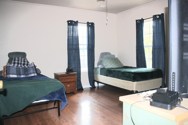 bedroom featuring crown molding, wood finished floors, and visible vents
