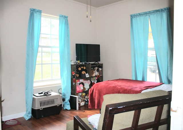 bedroom with ornamental molding and hardwood / wood-style flooring