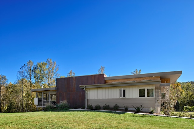 view of front facade with a sunroom and a front lawn