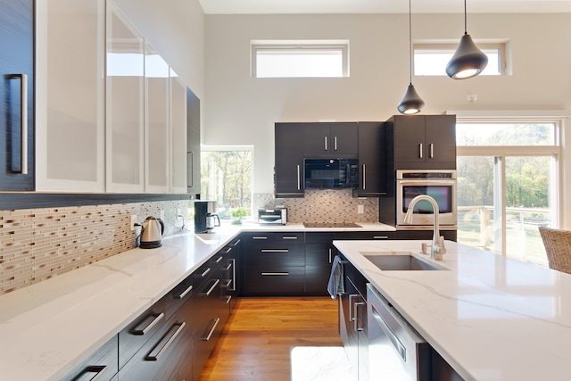 kitchen with white cabinets, plenty of natural light, hanging light fixtures, and black appliances