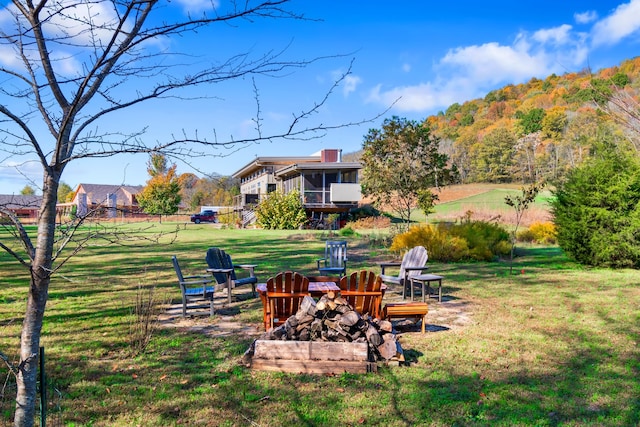 view of yard featuring a sunroom and an outdoor fire pit