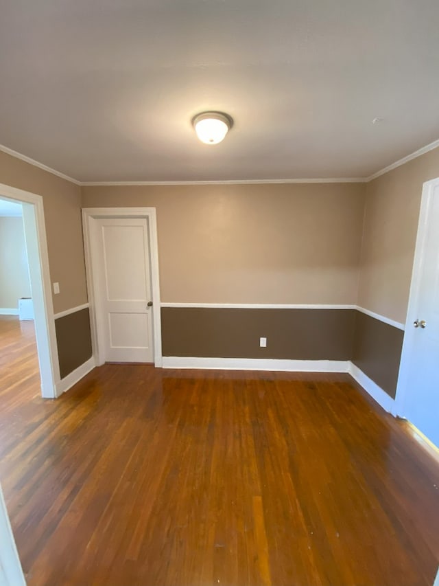 spare room with ornamental molding and dark hardwood / wood-style floors