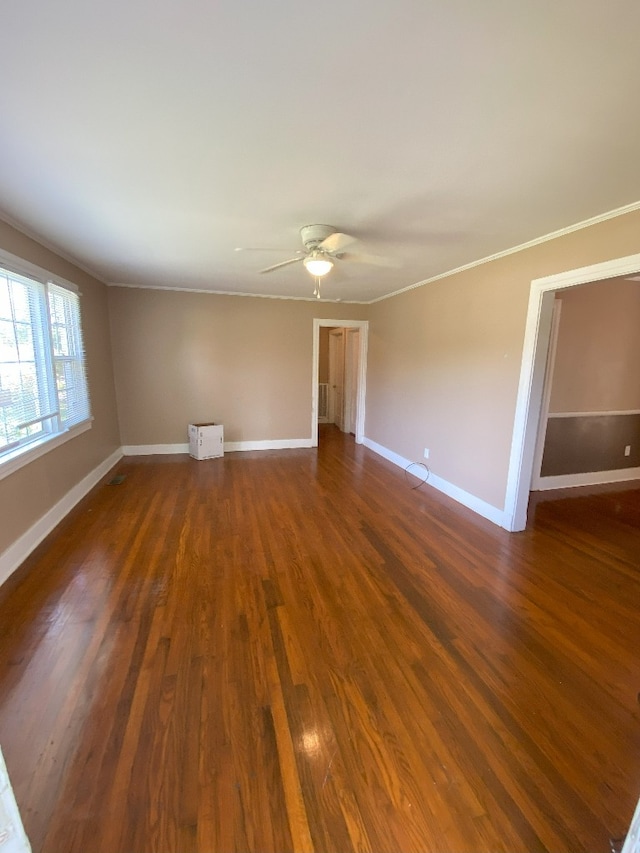 empty room with crown molding, dark hardwood / wood-style floors, and ceiling fan