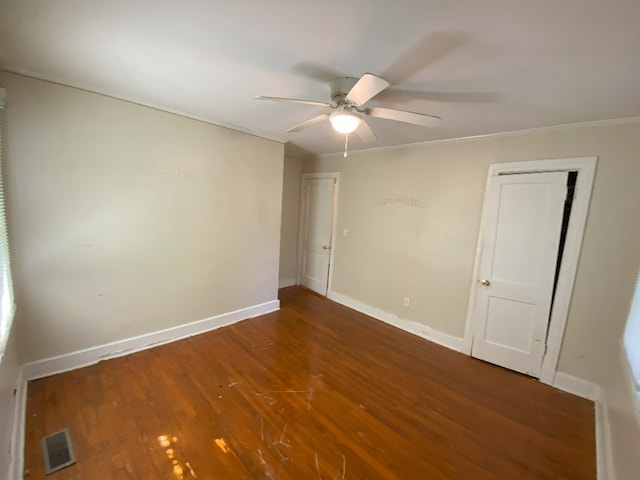 empty room with ceiling fan, crown molding, and dark hardwood / wood-style floors